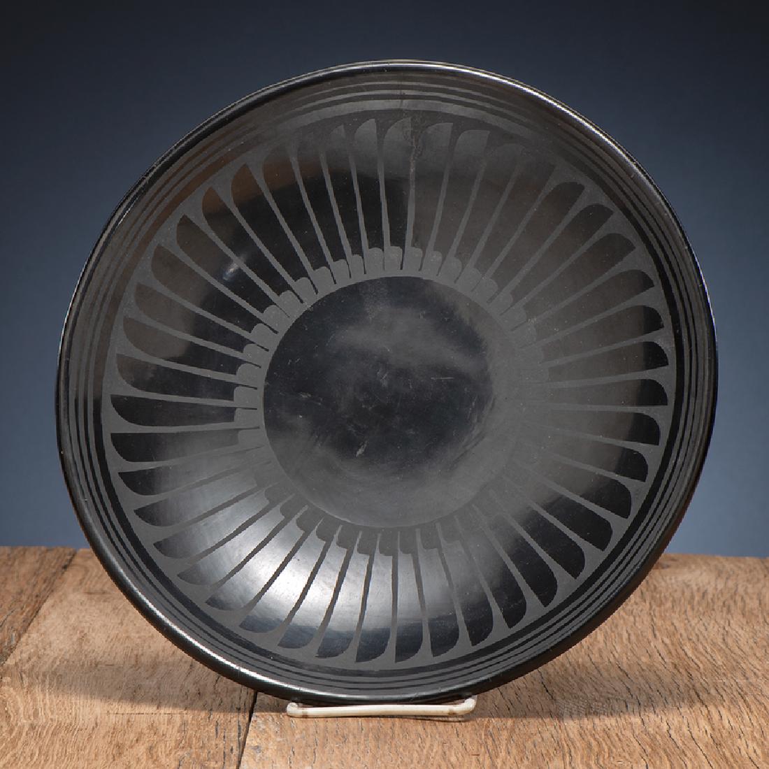 Maria and Santana Martinez (San Ildelfonso, 1887-1980 /: painted concentric circles decorate the rim and a repeating feather motif decorates the inside; signed on base; height 2 in. x diameter 11 in. 1943-1954
