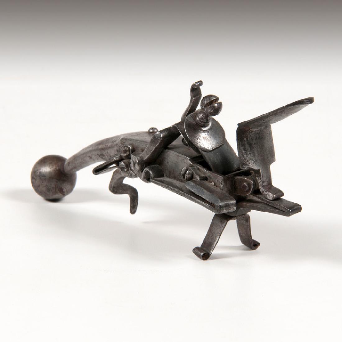 Iron Flintlock Tinder Lighter: Late 18th-early 19th century. An iron tinder lighter in pistol form with ball butt and hinged door in body; ht. 7.25, lg. 7.25, wd. 1.5 in.