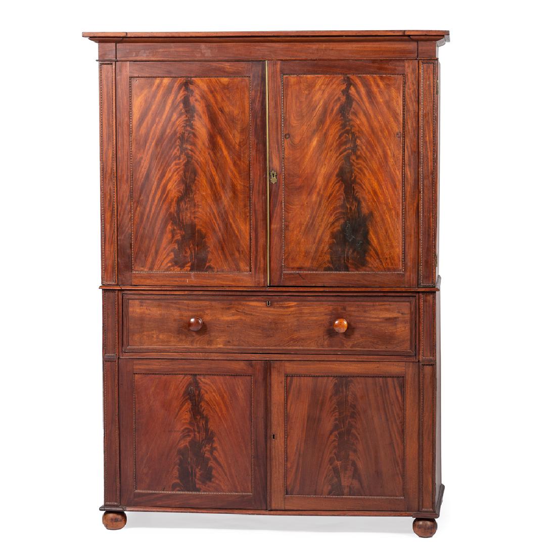 Georgian Linen Press: English, 19th century. A three-piece Georgian linen press in mahogany, having a removable shaped and molded cornice, the conforming upper case with hinged paneled doors and interior glides, single wai