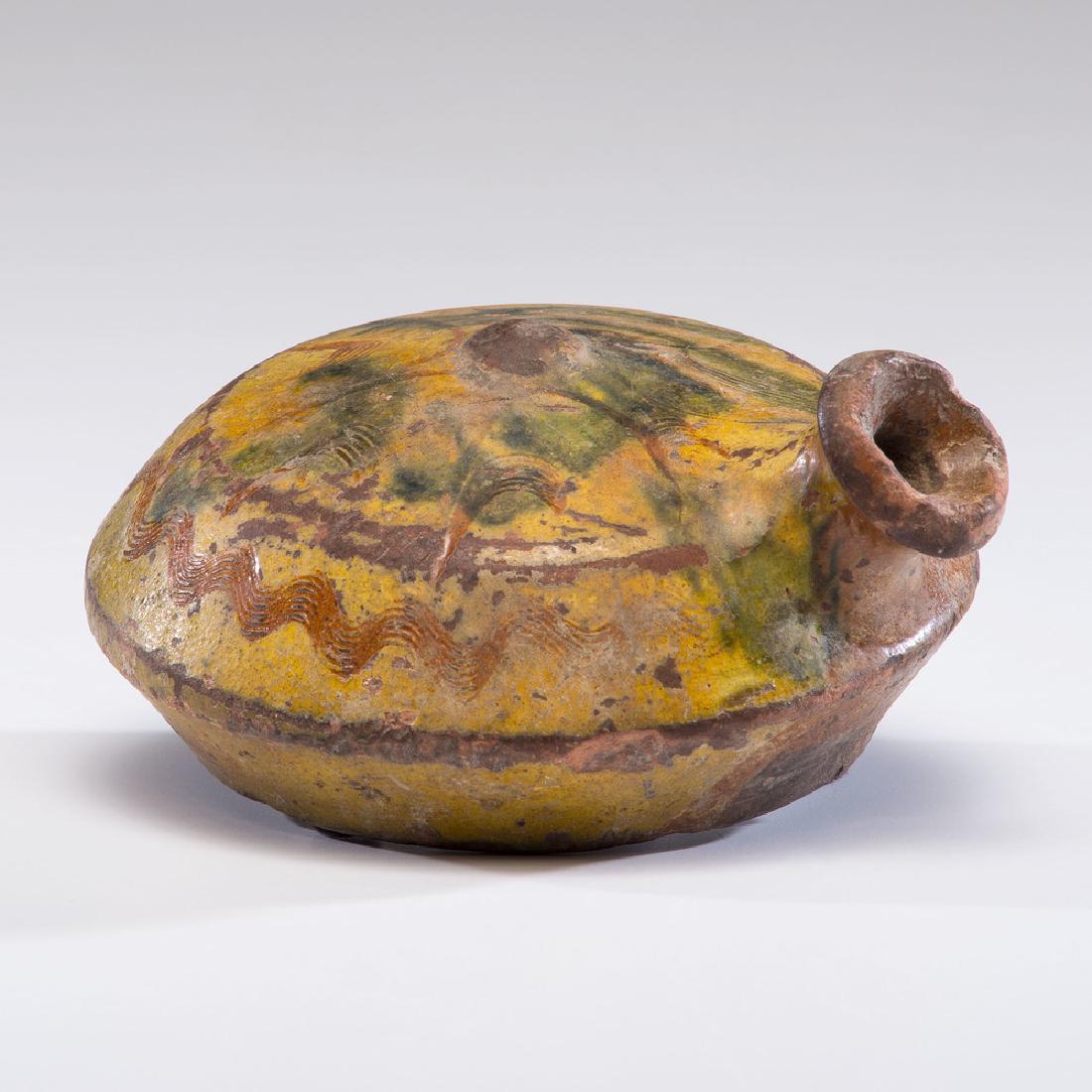 Tin-Glazed Redware Flask: American, 19th century. A tin-glazed redware flask with polychrome decoration and one side flat; dia. 5.25 in. Provenance: Property from the Americana Collections of Kenneth and Barbara Gruver, German