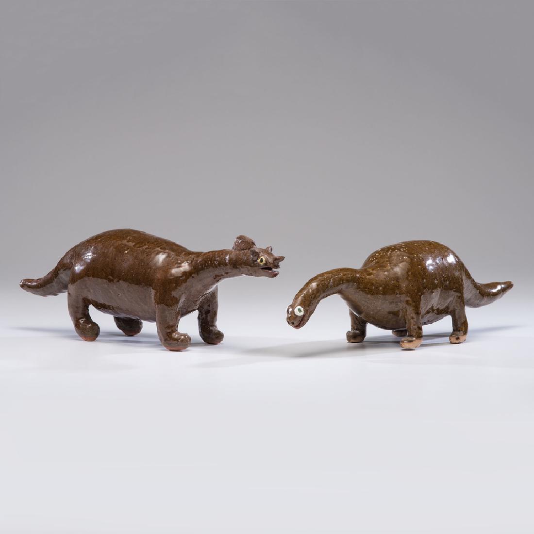 Reggie Meaders Stoneware Dinosaurs: American, 20th century. Two stoneware dinosaurs, underside of each incised Reggie Meaders ; larger ht. 6, lg. 20 in.