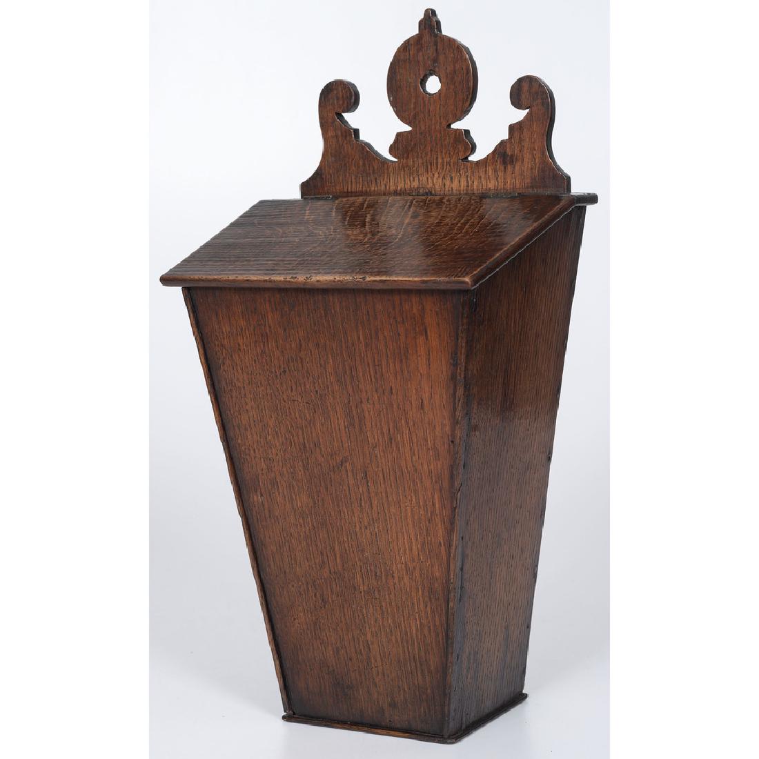 English Oak Hanging Knife Box: English, 18th century. A hanging knife box in oak, with carved crest, slant lid and tapered box; ht. 17.75, wd. 19.25, dp. 6 in. Provenance: Purchased from Swan Tavern Antiques, Yorktown, Virginia Pro