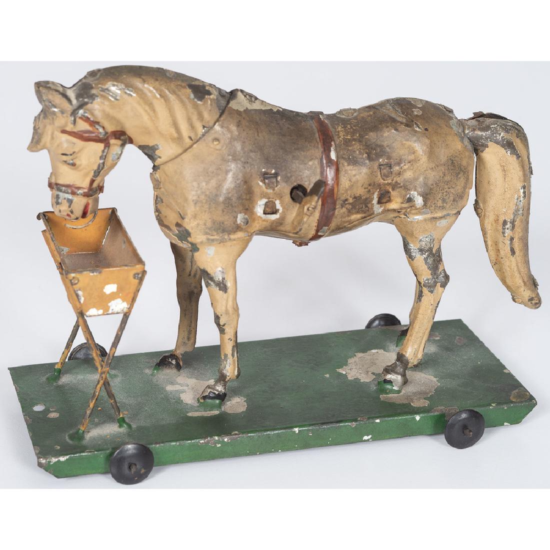 German Tin Toy Horse at Trough: German, 20th century. A toy horse mounted to rolling platform; ht. 5, lg. 7 in.
