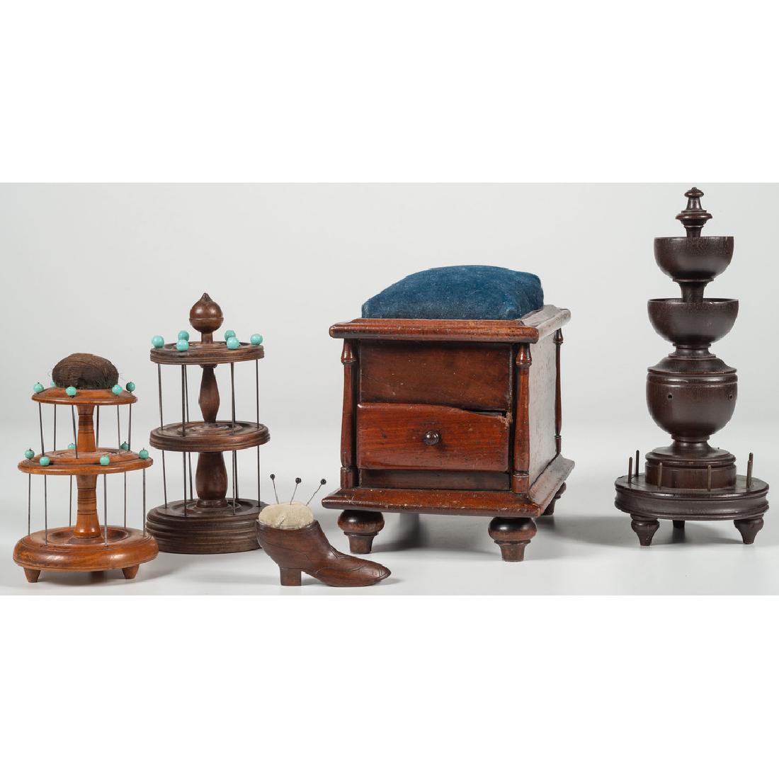 Turned Sewing Caddies and Sewing Box: American, late 19th-early 20th century. Three turned wood sewing caddies, a footed sewing box with a single drawer and large pincushion top, and a small wooden shoe-form pincushion; tallest caddy ht. 