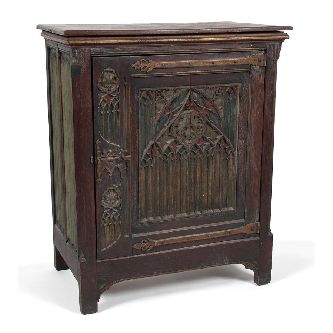 Gothic-Style Carved Music Cabinet: Gothic-Style Carved Music Cabinet Continental, late 19th century. A carved music cabinet, with rectangular top over molded cornice and single door with Gothic-style carvings and brass hardware, openin