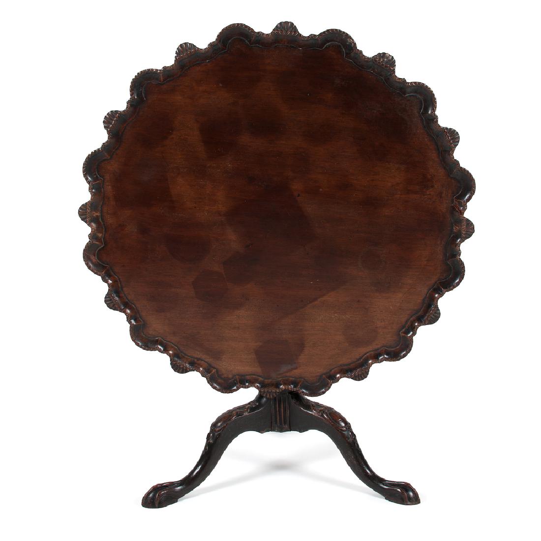 Pie Crust Tilt Top Table: Pie Crust Tilt Top Table English, late 18th century. A tilt top table in mahogany, having a pie crust surface over a turned and carved standard, all rising on and tripod cabriole legs with carved knee
