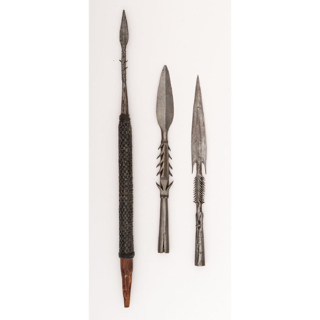 Lot of Three African Spearheads: Lot consists of three barbed spearheads, longest measuring 2.25". Third spearhead appears to be mounted on a support meant for attaching to a socket, perhaps another spear or thrower. Consistent w