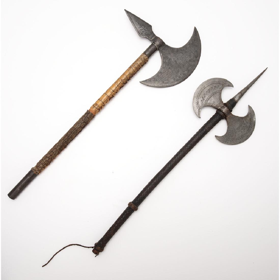 Lot of Two Battle Axes: Lot consists of two African/Middle Eastern battle axes, measuring 23" overall. Single and-double headed with reptile skin-wrapped hafts. Both examples show geometric motifs with single-edged examp