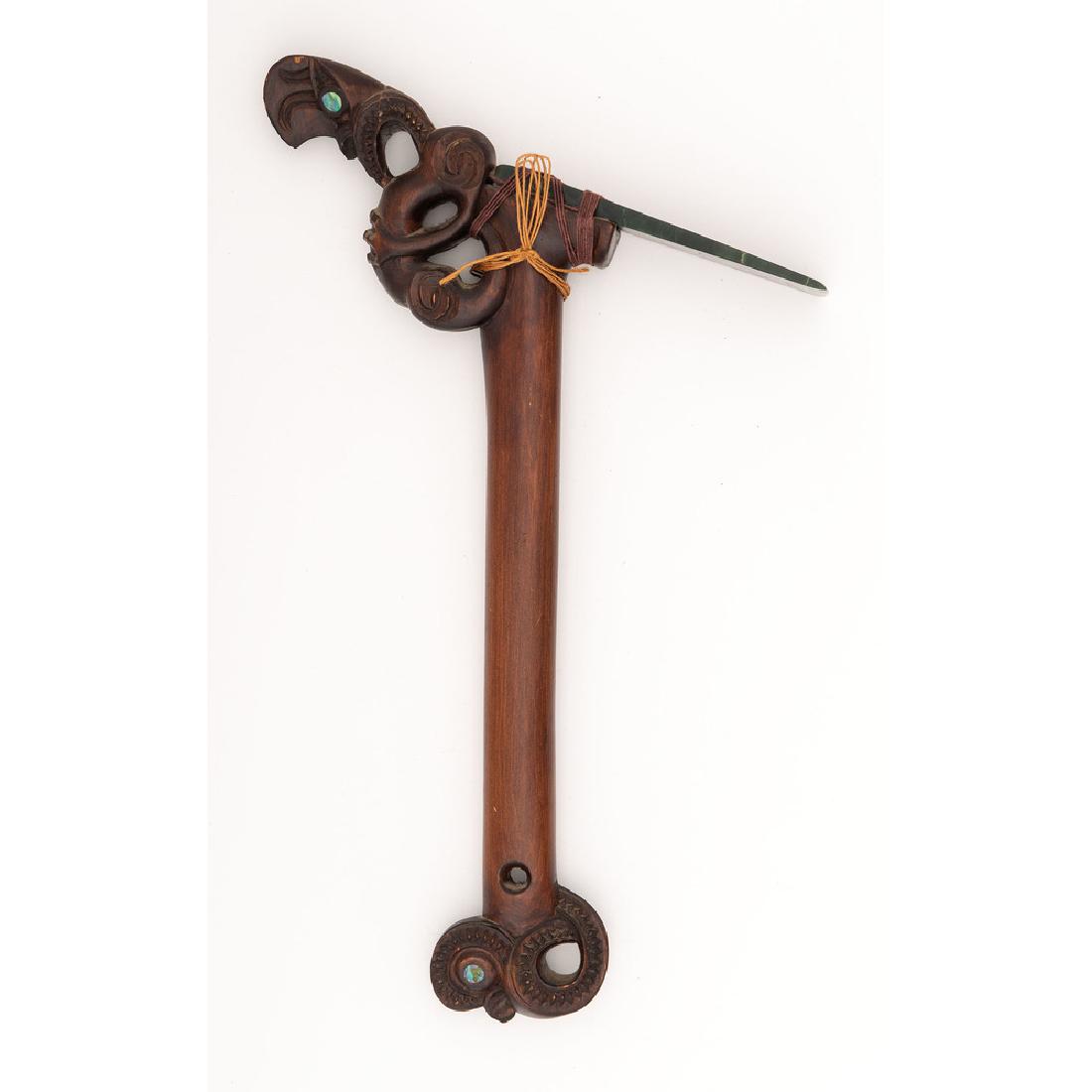 Contemporary Maori Adze: 18" x 10.75". Wood with nephrite angled blade. Haft cared in traditional figural forms with abalone eyes. 20th Century.