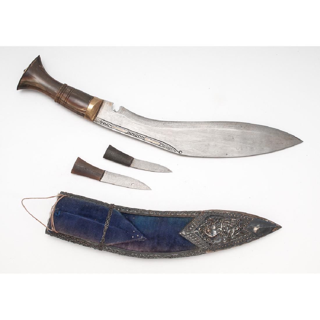 Nepali Kukuri with Silver Mounted Scabbard: 15" overall length, 10" blade. Handle made of cow horn with brass cap. Blade is in excellent condition with minimal engraving. Wood scabbard covered with velvet with silver furniture.