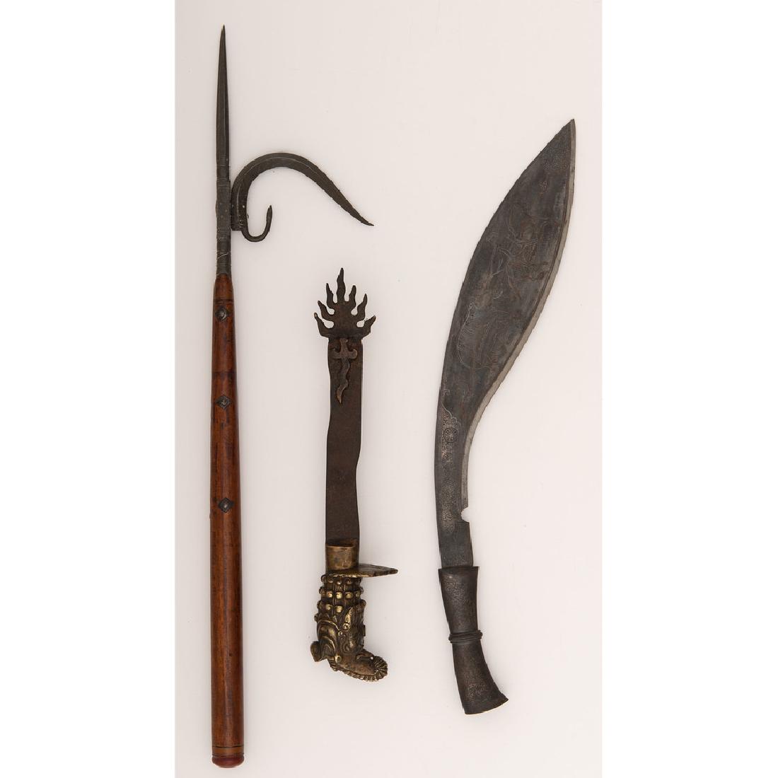 Lot of Indo-Tibetan Weapons: Lot consists of three weapons including a kukuri with 16.25" blade engraved with a scene of training elephants, one 26" elephant goad, and one Tibetan Khadga ritual sword with brass dragon hilt.