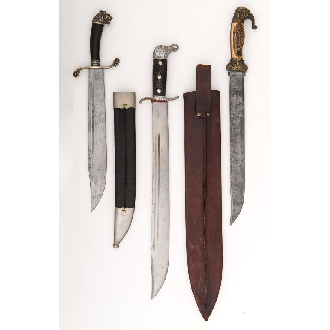 Lot of Three Machetes: Lot consists of three machetes, likely of Spanish market origin. Longest blade measures 18". Manufacturers include Collins & Company, Shurhoff, and Theile & Quack. Brass, nickel, and German s