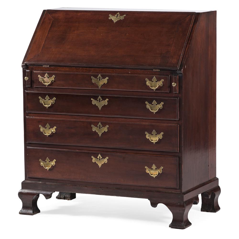 Chippendale Slant Front Desk: American, 18th century. A slant front desk in cherry, having a writing surface with fitted interior desk, the tombstone paneled central prospect with leaf and vine carving, flanked by six pigeon holes