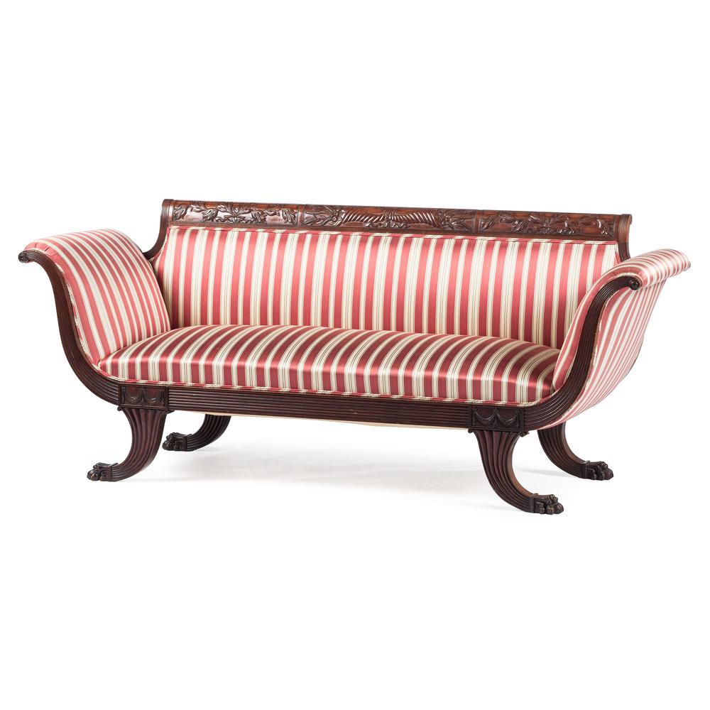 Late Classical Style Carved Sofa: American, 19th century. A Late Classical style mahogany sofa in the manner of Duncan Phyfe, having a straight carved crest rail with scrolled arm supports and straight reeded seat rail, rising on outs