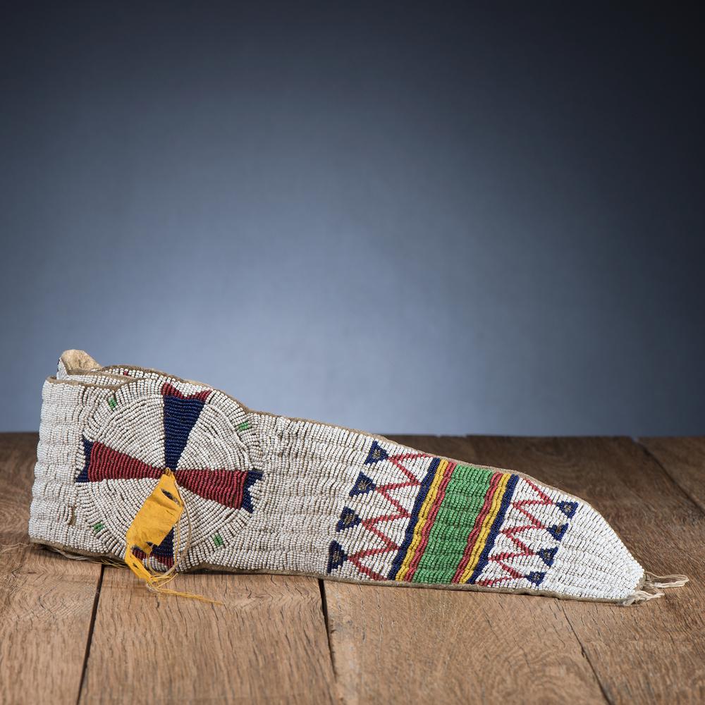 Sioux Beaded Hide Blanket Strip, From the Stanley B.: thread and sinew-sewn on hide; geometric beaded designs in colors of pea green, red white-heart, navy blue, greasy yellow, and facetted silver on a white background; length 74 in. late 19th century Pr