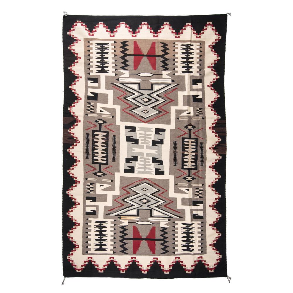 Navajo Storm Pattern Roomsize Weaving / Rug, From the: woven in red, cream, black, and red; central storm surrounded by an interlocking, zigzagging border, 130 x 84 in. third quarter 20th century Provenance: From The Harriet and Seymour Koenig Collection,