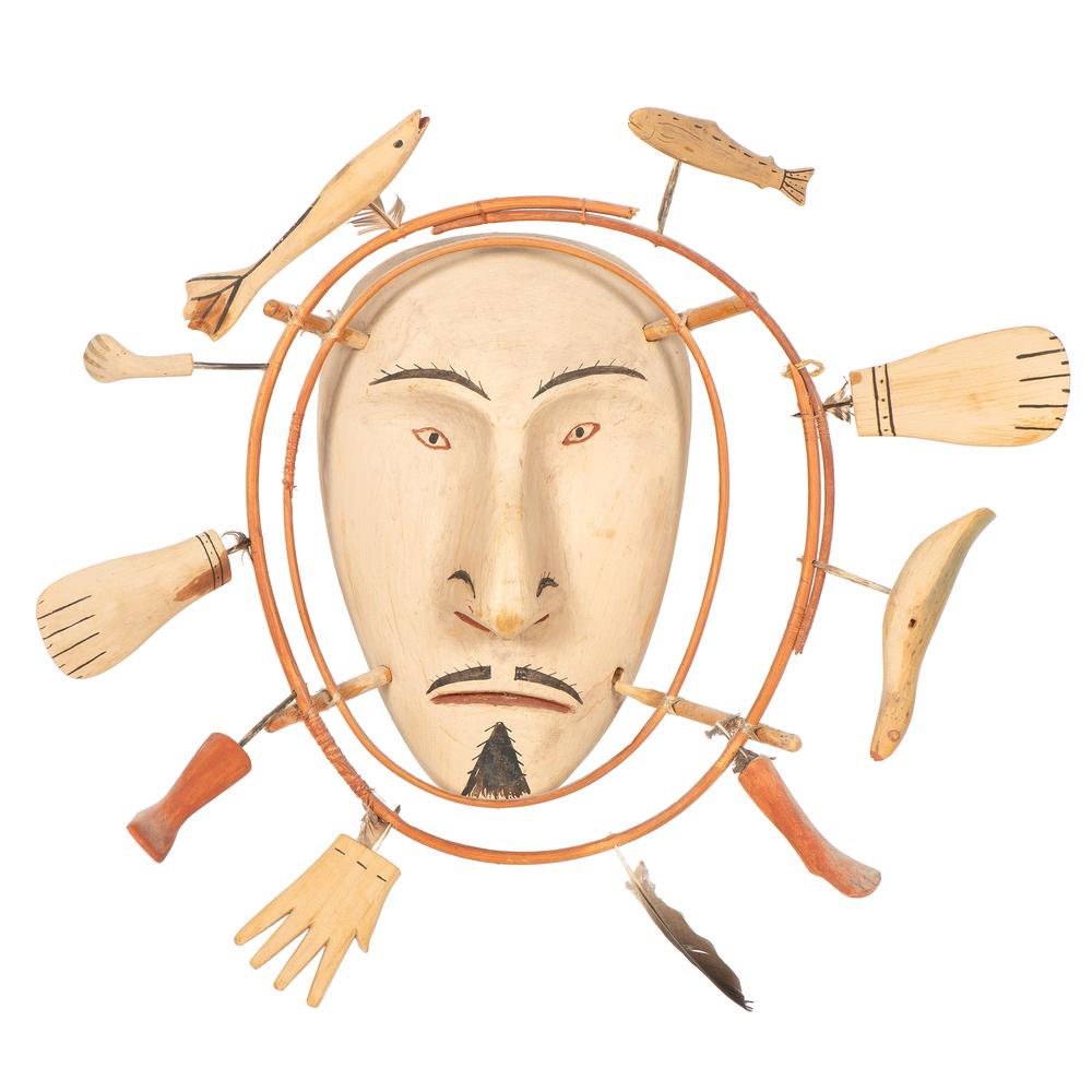 Nunivak Island Inua Painted Wood Mask, From the William: carved wood face surrounded by two concentric, bentwood halos; hand, legs, flippers, and fish are set in outermost ring, overall diameter 17.5 in. second quarter 20th century