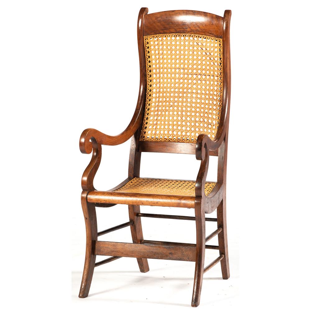 Late Empire Armchair: American, 19th century. A Late Empire armchair in cherry, having a straight crest, continuous scrolling stiles, caned back and seat, rising on sabre legs with stretcher support; ht. 46, wd. 21, dp. 25