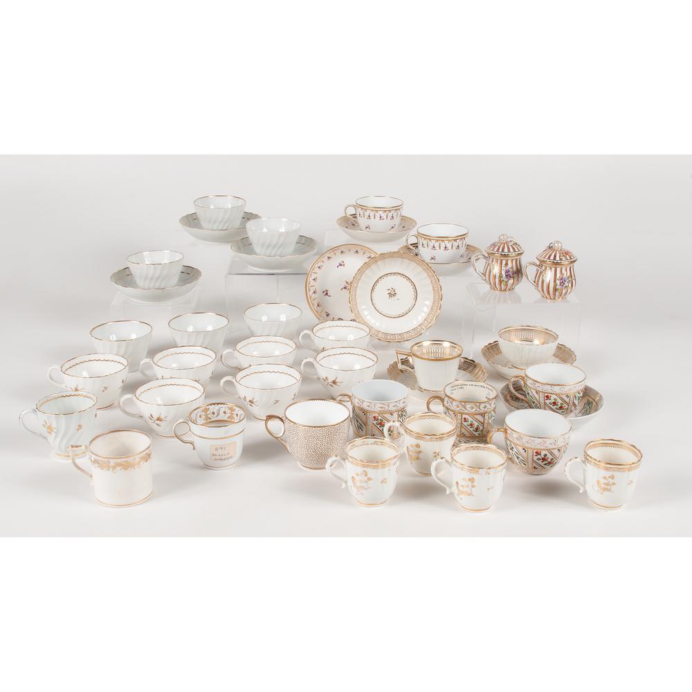 English Gilt Porcelain, Including 18th Century: English. An assembled group of thirty-three gilt tea wares including six ribbed swirl teacups, three with saucers, two Spode "bute shape" teacups in pattern #1137 with purple flowers and three matchin