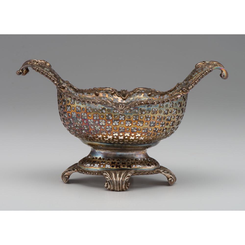English Sterling Center Basket: English (London), ca 1761. A George III sterling basket with scrolled rim and feet, the bowl pierced with alternating star and clover pattern. With full hallmarks to underside including maker's mark T