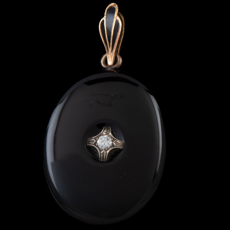 Black Onyx and Diamond Locket: Black Onyx and Diamond Locket Black Onyx and Diamond Locket Containing one full cut diamond approximately 0.14 carat. 1.5" x 1" suspended from a 14k gold and black enamel bale.