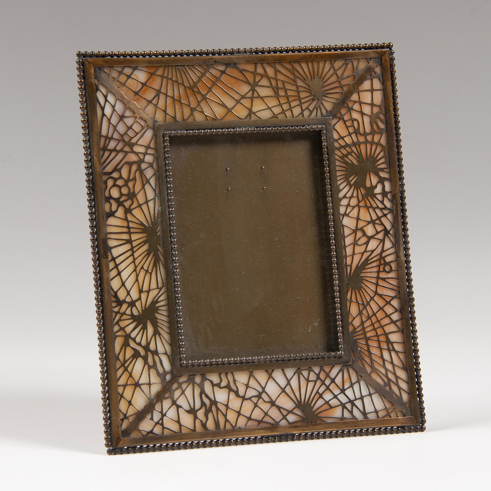 Tiffany Studios Pine Needle Picture Frame: Tiffany Studios Pine Needle Picture Frame American, early 20th century. A Tiffany Studios picture frame in pine needle pattern with slag art glass, kickstand on back, marked Tiffany Studios / New 