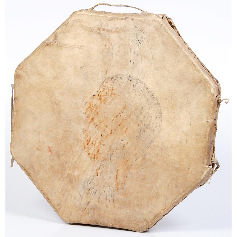 Painted Hide Drum PLUS: lot of 2, includes a large octagonal drum with wood frame and covered with thick hide; face of drum painted with the portrait of a warrior, diameter 25 in.; AND a rawhide hobble, length 13.5 in. first