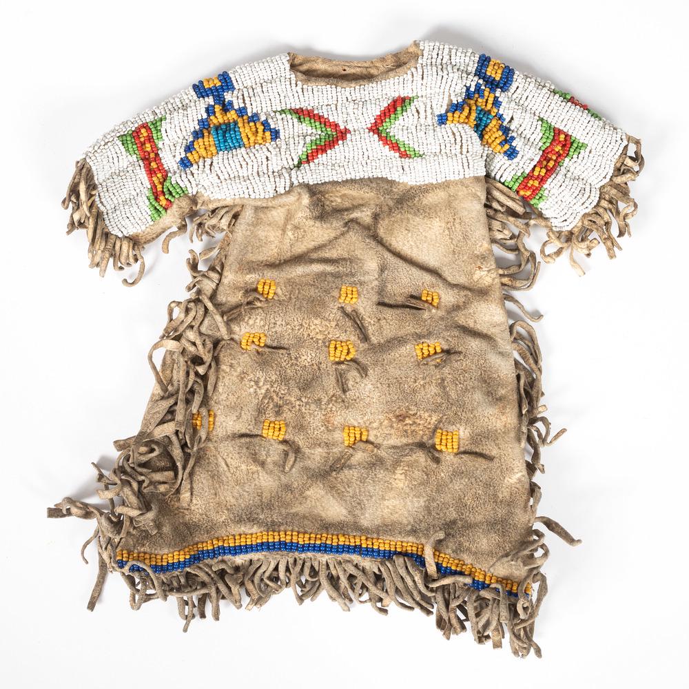 Sioux Beaded Hide Doll Dress: beaded on hide in colors of white, red, green, yellow, blue, and light blue; length 9.5 in. x width 9.5 in. first quarter 20th century Provenance: From the Stanley B. Slocum Collection, Minnesota