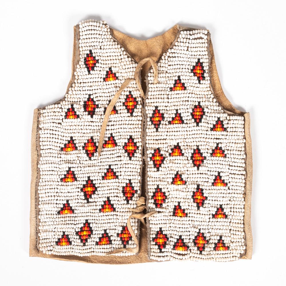 Sioux Child's Doll Beaded Hide Vest: thread-sewn on hide scraps using colors of white, black, red, orange, and yellow; length 5.75 in. early 20th century