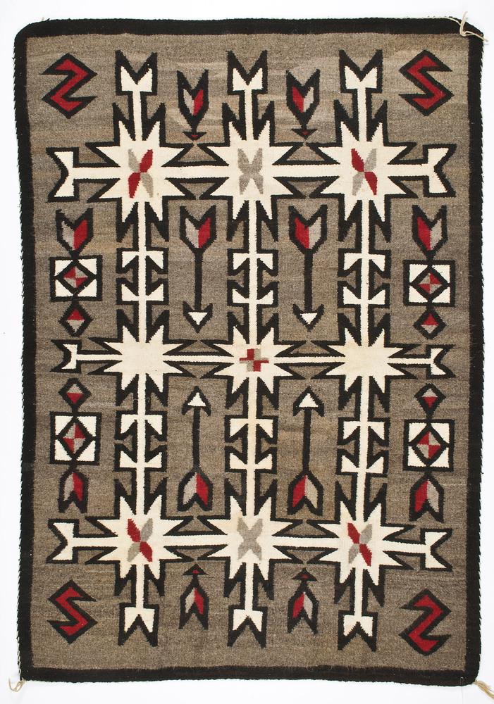 Navajo Western Reservation Weaving / Rug: hand-spun thick woven wool creating a bold interlocking decoration of six-pointed stars, tuning fork devices, and arrows; 72 x 50 in. first quarter 20th century Provenance: From the Estate of Jane Mur