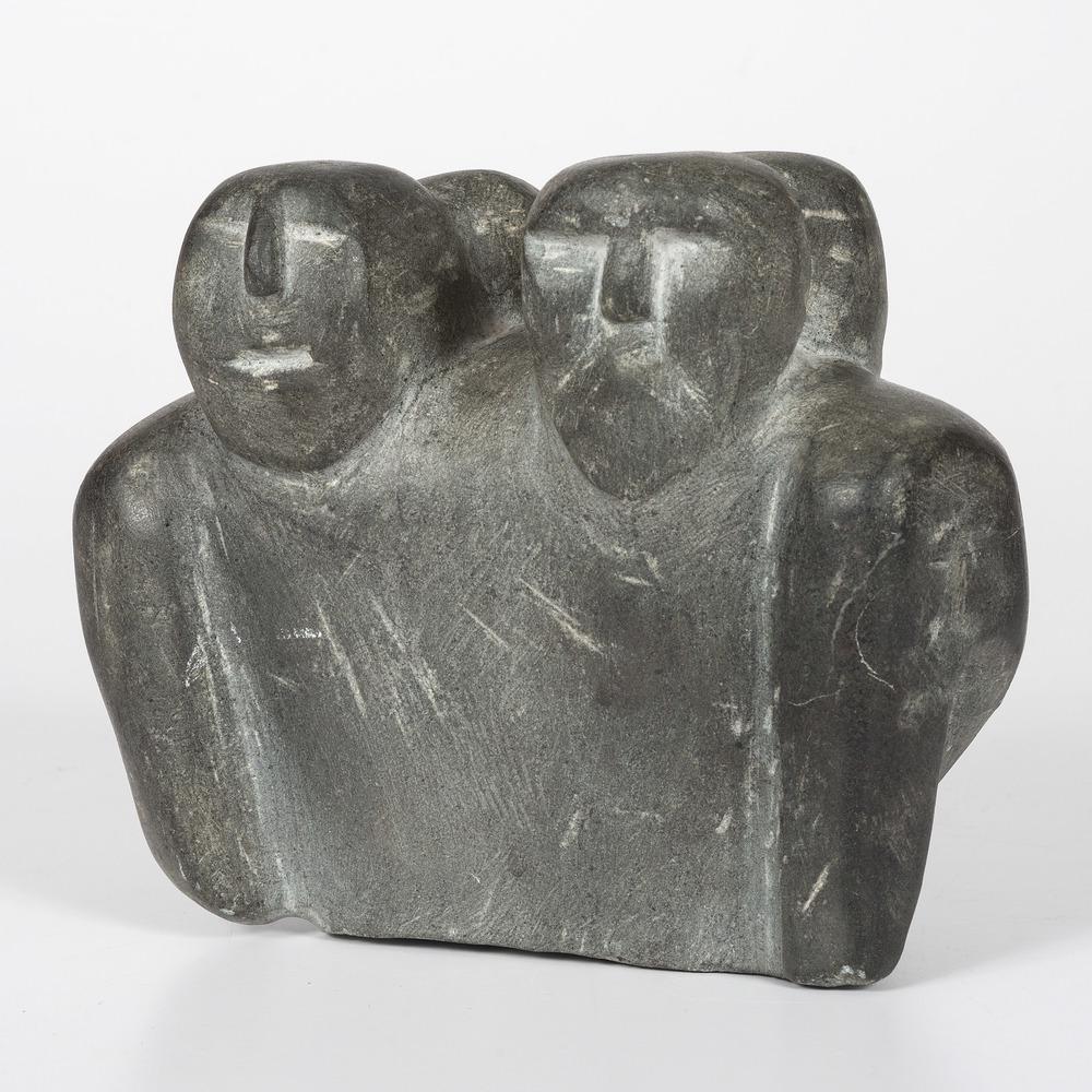 Carved Inuit Soapstone Sculpture: sculpture carved with four faces, two on the obverse and two on the reverse; signed illegibly on base, height 6.5 in. x width 8 in. 1966