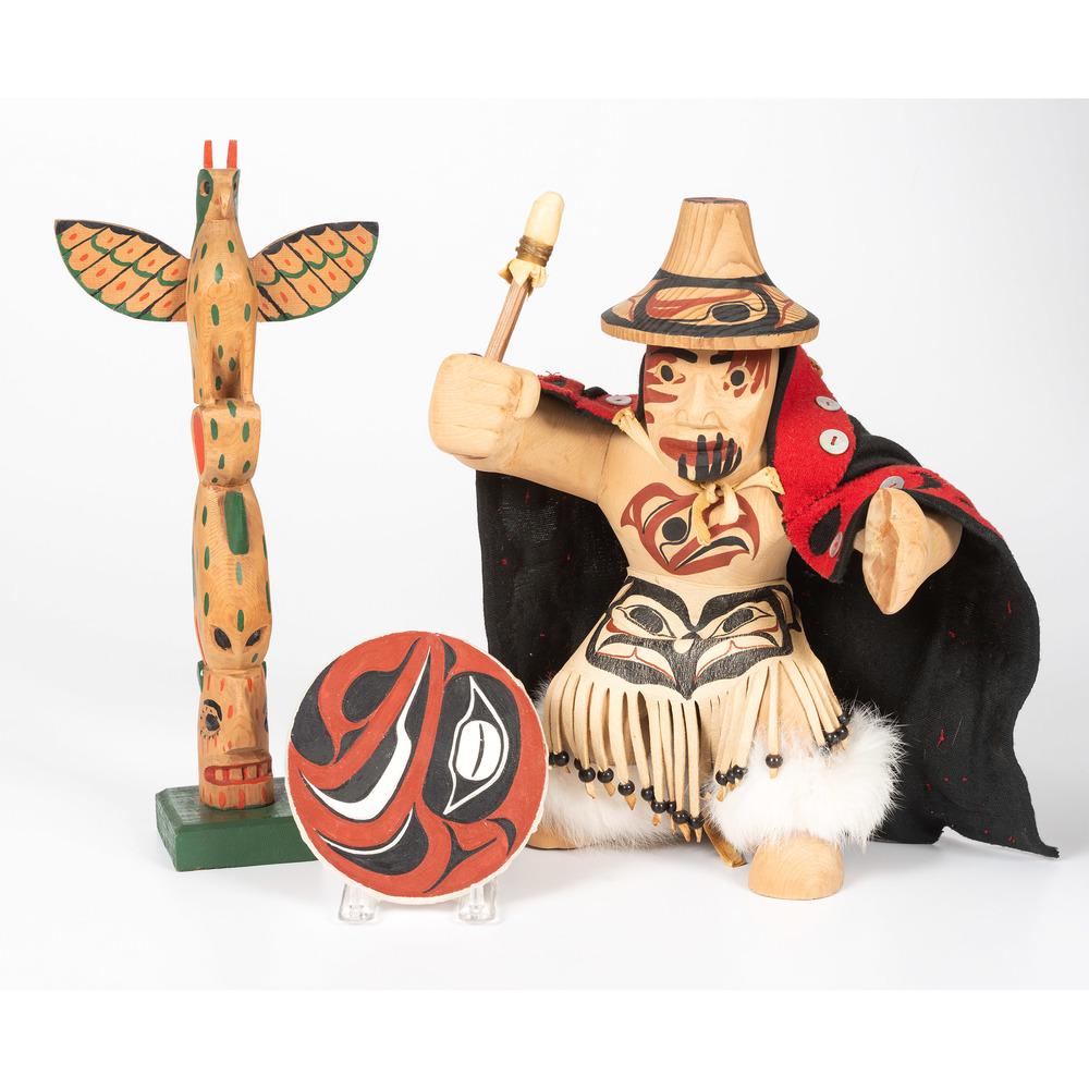 Northwest Coast Carvings, PLUS: lot of 3, includes Northwest Coast carved wood figure wearing a black and red cape and carrying a painted shield, height 11.5 in.; PLUS a Northwest Coast miniature totem pole, painted in colors of r