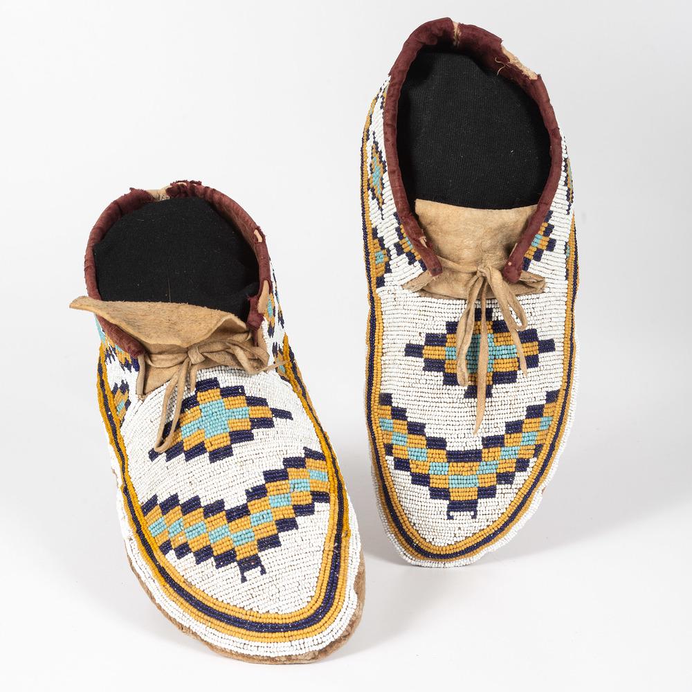 Plains Cree Beaded Soft-Soled Moccasins: thread-sewn; with canvas uppers and hide soles; uppers beaded in colors of gold, deep blue, light blue, and white; velveteen interior, length 10 in. late 19th century