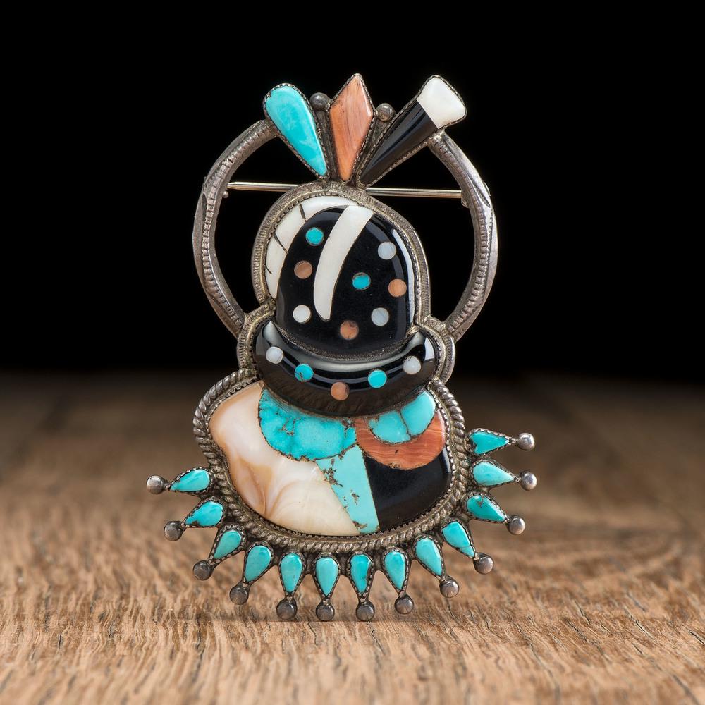 Leo Poblano (Zuni, 1905-1959) Attributed, Silver and: Leo Poblano (Zuni, 1905-1959) Attributed, Silver and Mosaic Inlay Zuni Fire God Brooch / Pin silver pin / brooch in the shape of a Zuni Fire God; turquoise, shell, coral, and jet mosaic inlay; not mar