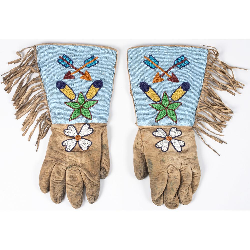 Plateau Beaded Hide Gauntlets, with Arrows: thread-sewn on soft hide, lined with a red floral cotton backing, and edged with hide fringe; fronts are beaded with crossed arrows, feather, star, and a flower design in colors of orange, translucen