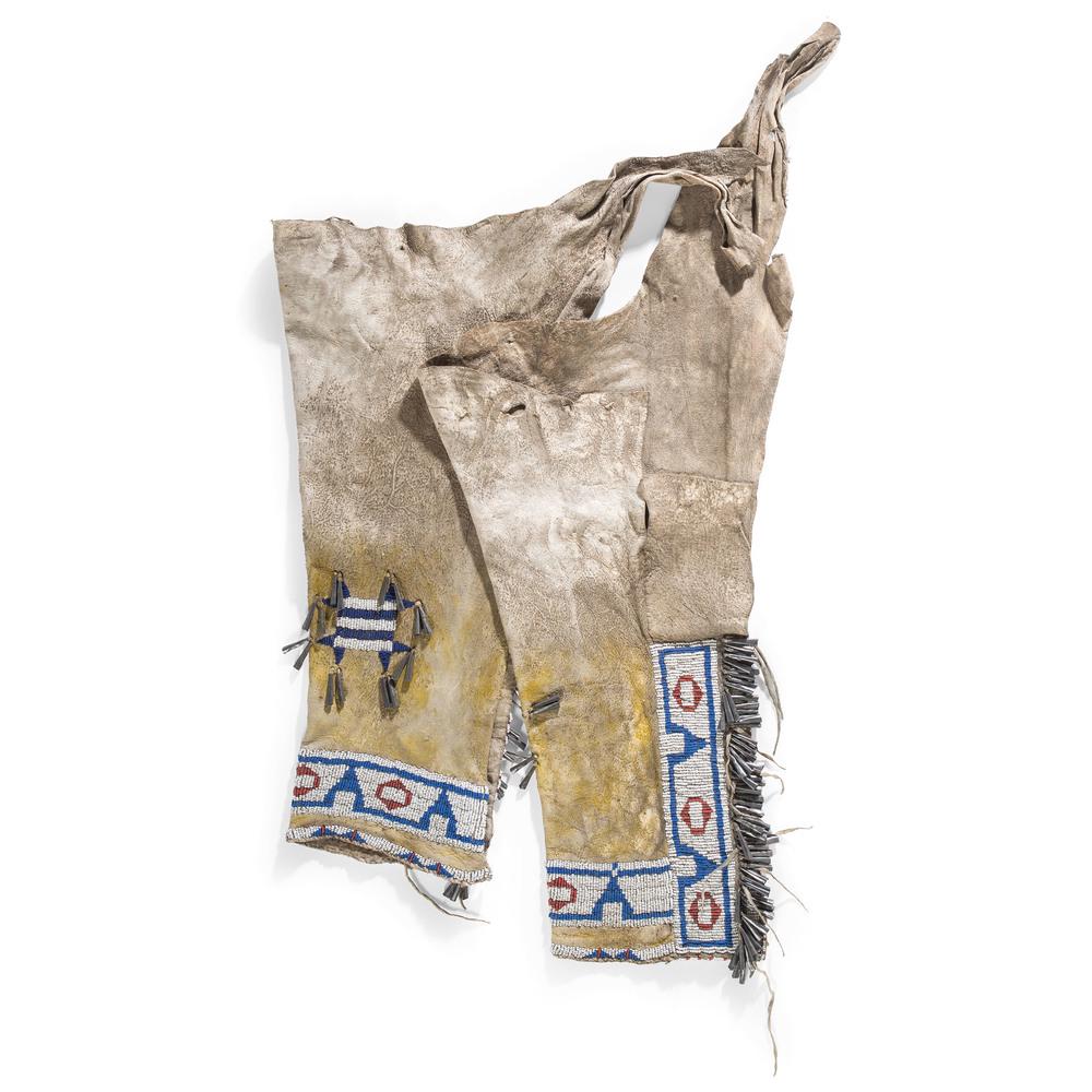 Arapaho Beaded Hide Leggings: thread and sinew-sewn softly tanned hide; beadwork in red white-heart, medium blue, and white; hide coated in yellow pigment; tin cones; collection number inked on interior, overall length 22 in. late