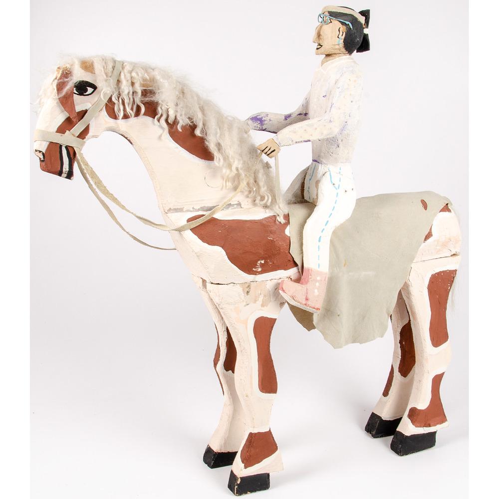 Delbert Buck (Dine, b. 1976) Wood Sculpure: of a man wearing wire rim glasses riding his pinto; signed on hoof, height 32.5 x length 30 in.
