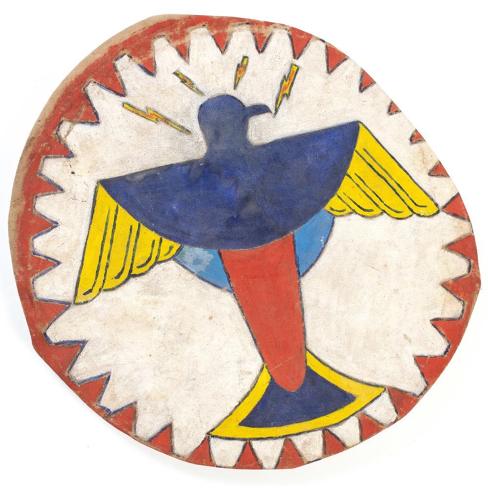 Plains Painted Canvas Drum Cover: with thunderbird image,thought to be insignia for the Native American Military Brigade located in Norman, OK, painted in bright colors of red, yellow, dark blue, and light blue on a white background; 