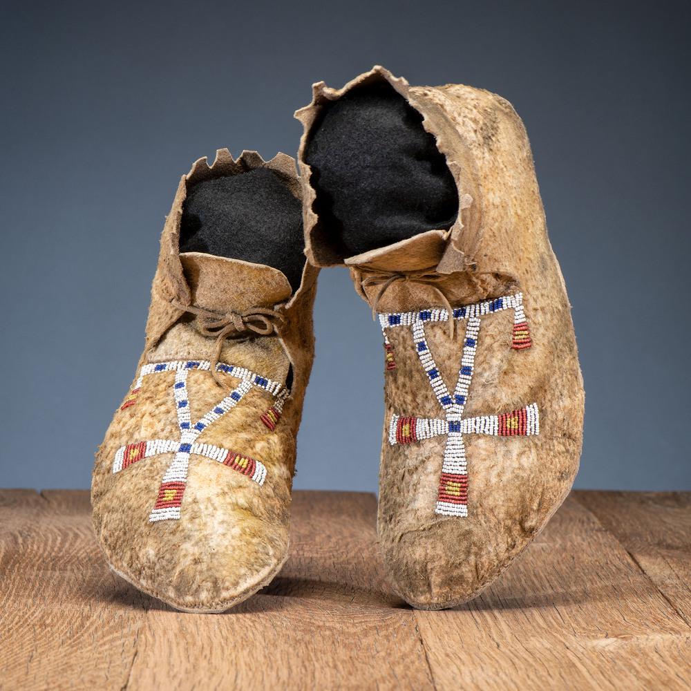 Arapaho Beaded Buffalo Hide Moccasins, with Dragonflies: Arapaho Beaded Buffalo Hide Moccasins, with Dragonflies thread and sinew-sewn on buffalo hide with high ankle and pinked cuffs; geometric beaded design on vamps in colors of red white-heart, greasy ye