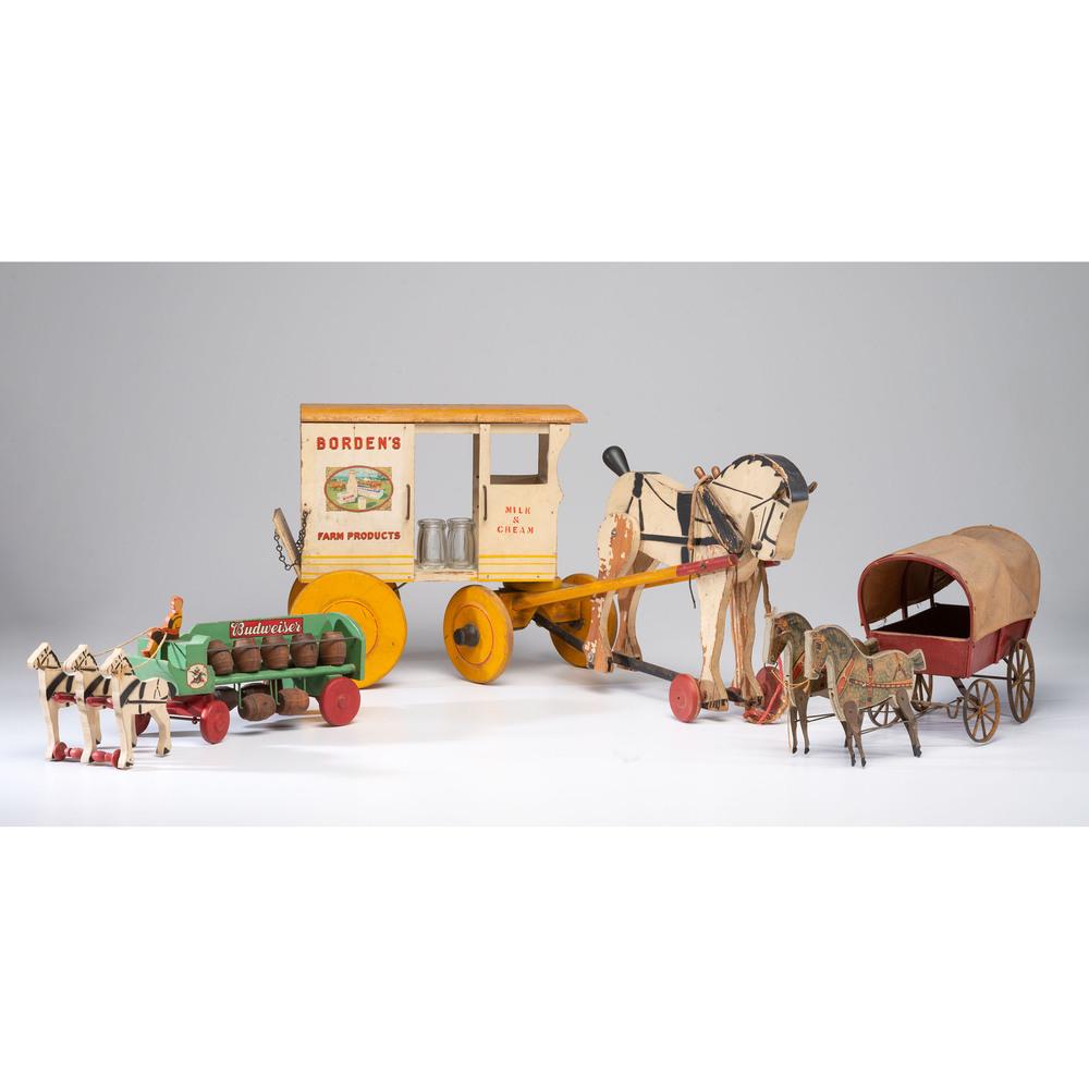 Three Wooden Wagon Pull Toys: Early 20th Century including a painted wood Budweiser wagon, a Borden's dairy wagon and a covered wagon. Length of largest 33 inches. Provenance: Property from the Estate of Joan Conway Crancer, St. L