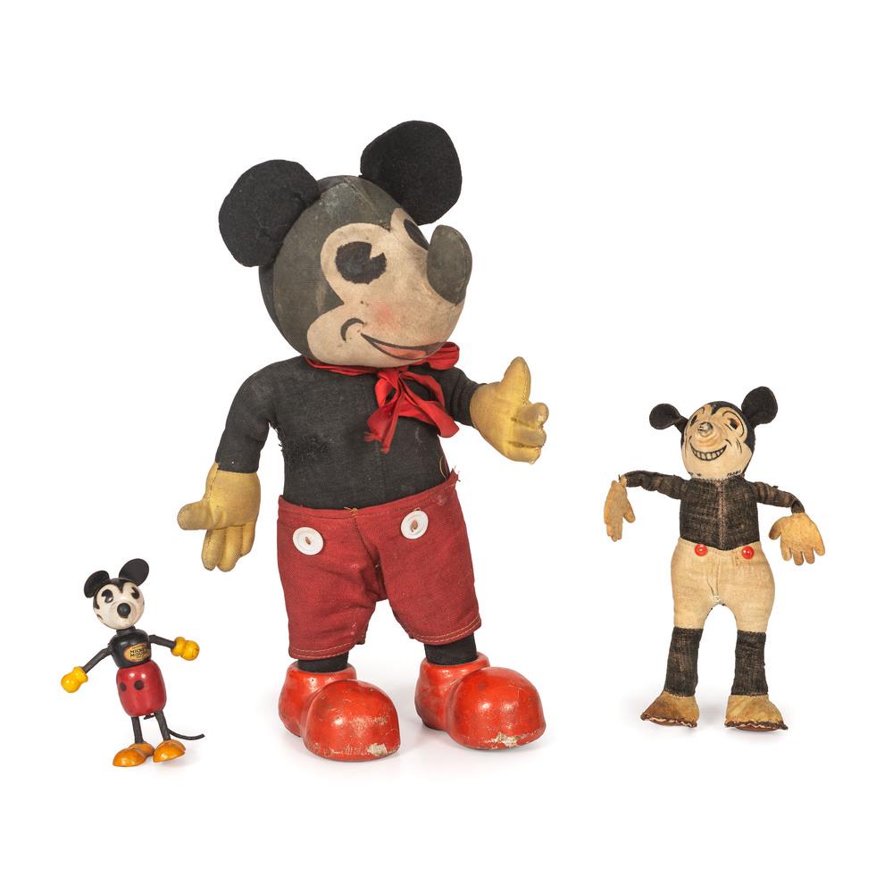 Three Early Mickey Mouse Toys: Early 20th Century including a Knickbocker Mickey doll, an early velvet example, and a painted wood Mickey with original sticker. Height of largest 12 inches.