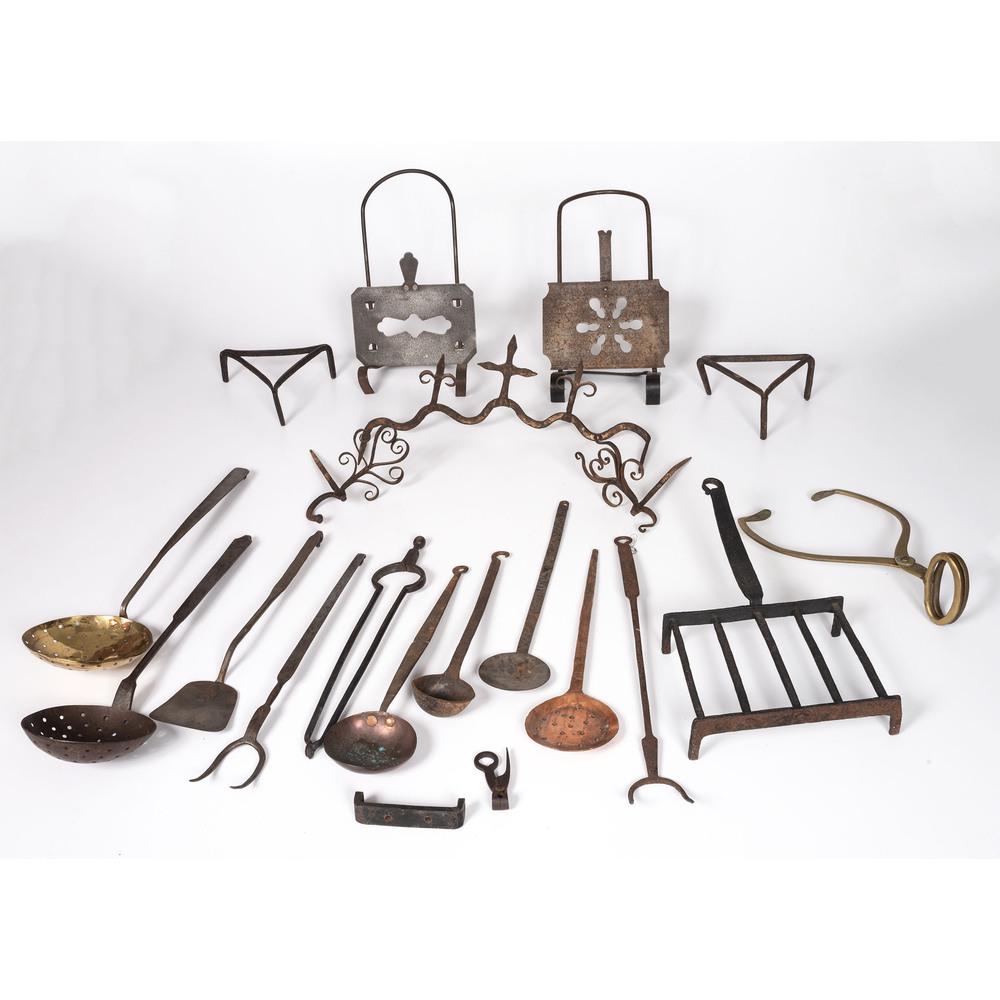 A Group of Cast Iron Tools and Utensils: 19th/Early 20th Century twenty items, including ladles, trivets, tongs, hooks, and a bullet mold. Length of largest 24 3/4 inches.