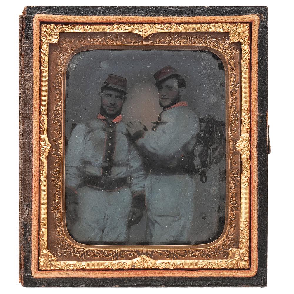 Sixth Plate Ambrotype of Possible Louisiana Rebels with: Sixth plate ambrotype of two unidentified soldiers, each carrying a backpack and wearing a blue-tinted uniform with dark placket and cuffs together with applied red collar and red forage cap. The co