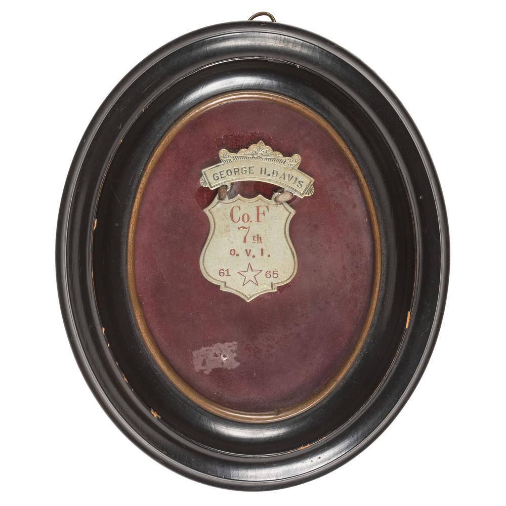 GAR Shield Badge, Private George H. Davis, Ohio 7th: GAR brass badge, approx. 2 x 2.5 in., framed to 6 x 7 in. Engraved "George H. Davis / Co. F / 7th / OVI / 61 [star] 65." George H. Davis enlisted on June 20, 1861 and was mustered in the same day as 