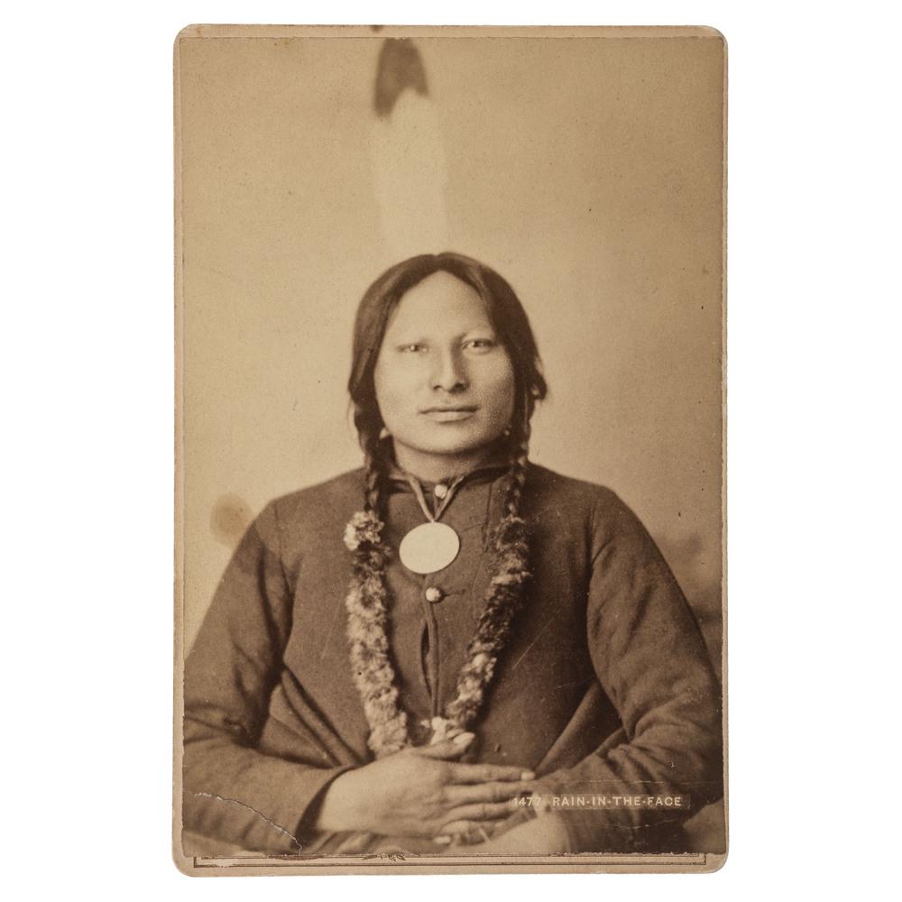 Rain-In-the-Face Cabinet Card by Haynes: Cabinet card of Lakota war chief Rain-in-The-Face (ca 1835-1905) in a seated pose, wearing a military jacket and presidential peace medal. The albumen photograph is slightly oversized, measuring appro