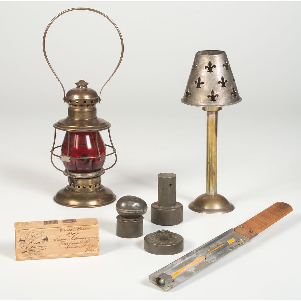 An Assortment of Metal Accessories: An Assortment of Metal Accessories 20th Century Includes a lantern, a candlestick, a cooking thermometer, three cookie and donut cutters, and five eye glasses. Largest height 13 inches.
