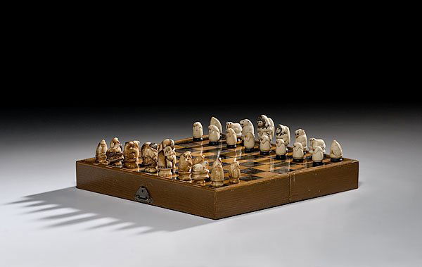 Eskimo Carved Walrus Ivory Chess Set, : Eskimo Carved Walrus Ivory Chess Set, early-mid 20th century housed in a wooden box opening to playing board; fossilized and unfossilized pieces ranging in size from 1.25" to 2.25"; board 12.25" squ