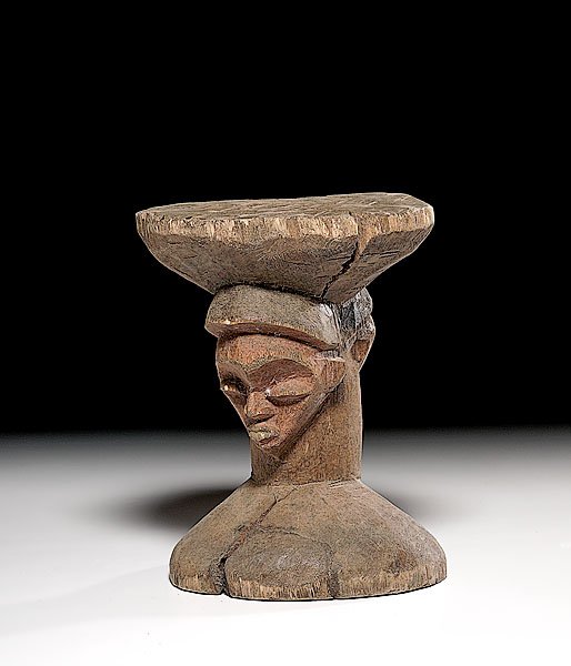 African Wooden Stool with Two Faces, : African Wooden Stool with Two Faces, ca last quarter 20th century each with red pigment and each looking in opposite direction. Stool with partial paper label stating "Made in Z..." probably for Zai
