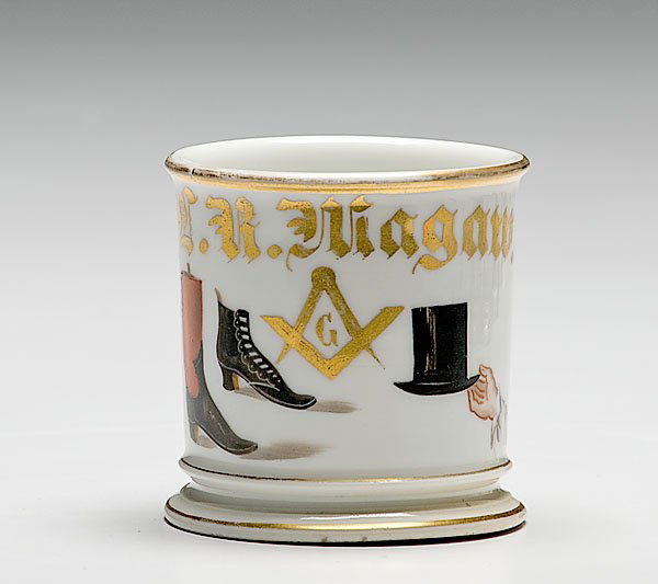 Boot and Hat Maker's Occupational Shaving Mug, : Boot and Hat Maker's Occupational Shaving Mug, porcelain, with polychrome painted scene of two boots and a hand holding a hat with a Masonic symbol in between the two. Gilt name L.K. Niagaw.