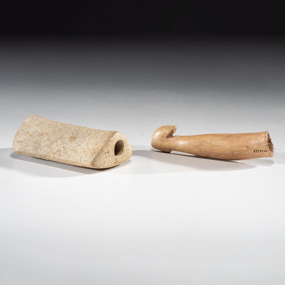 A Hardstone Saddle Bannerstone and Associated Antler: Middle - Late Archaic Period, 8000-1000 B.C. Kentucky Hook is expertly restored. lot of 2, lengths 3-3/4 in. and 3 in. Collection History: Gerber Collection Numbers: AG.B25 & AG.SB238 Found by Floyd S